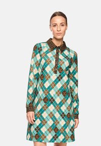 Langärmliges Kleid mit einem türkisbraunen und cremefarbenen Rautenmuster, einem Leopardenmuster-Kragen und Knopfleiste.