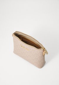 Beige zipped pouch in textured material featuring a subtle pattern, gold hardware, and a branded logo on the front. Interior reveals tan lining.
