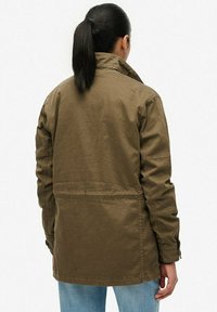 Olivengroene katoenmix jas met militair-stijl kraag, zijzakken en rugventilatie. Gladde textuur, ontspannen pasvorm en lange mouwen.