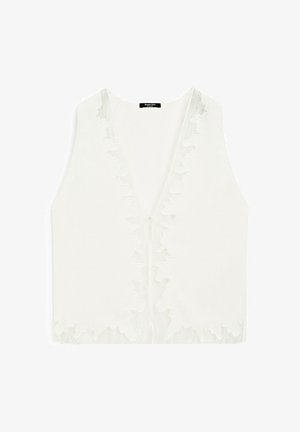 Bílá bezrukávová blůza s hlubokým V-výstřihem, se jemnými krajkovými detaily podél okrajů a hladkou, lehkou texturou látky.