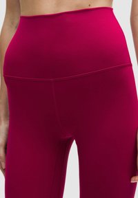 Legginsy z wysokim stanem w intensywnym kolorze fuksji, wykonane z gładkiej, elastycznej tkaniny. Charakteryzują się bezszwowym krojem z delikatnymi detalami przeszyć.