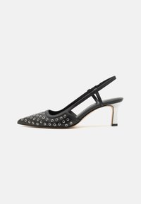 Escarpins noirs à bride arrière avec un bout pointu, ornements en œillets métalliques, en cuir lisse, et un design de talon bicolore.