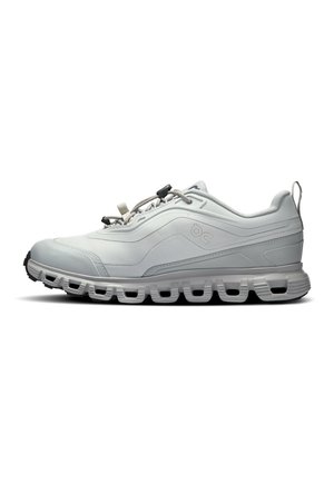Scarpa sportiva grigio chiaro con tomaia strutturata, design elegante, punta arrotondata e suola ammortizzata con dettagli traforati. Include lacci regolabili.