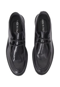 Scarpe in pelle nera con una texture liscia, forma arrotondata e cuciture a contrasto. Design con lacci e etichetta "Made in Italy" all'interno.