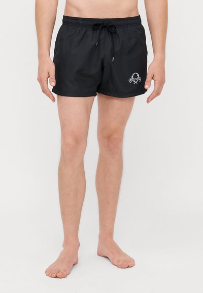 Schwarze Badehosen aus leichtem Stoff, mit einem elastischen Bund und Kordelzug sowie einem kleinen gestickten Logo auf einer Seite.