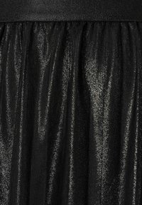 Schwarzer Tüllrock mit einer strukturierten, glänzenden Oberfläche, ausgestattet mit einem gerafften Bund und einem weichen, fließenden Erscheinungsbild.