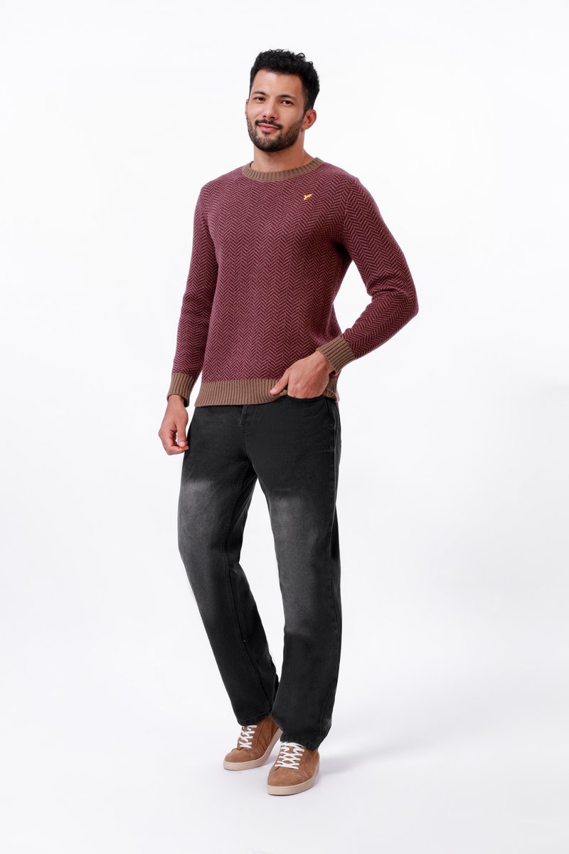 Czerwono-brązowy sweter w jodełkę z ribbowym dekoltem i mankietami, w połączeniu z czarnymi, przetartymi dżinsami i brązowymi zamszowymi sneakersami.