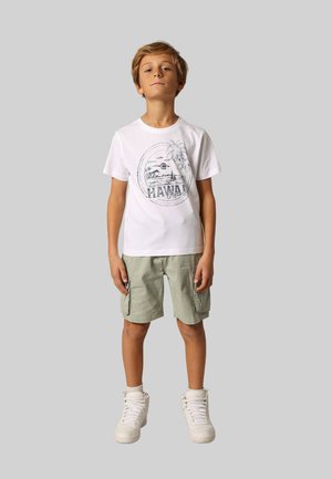 Witte katoenen T-shirt met een grafische print van palmbomen en de tekst "Hawaii", gecombineerd met lichte groene cargoshorts en witte sneakers.