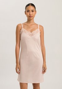 Abito a camicia rosa chiaro con spalline sottili e dettagli in pizzo lungo il collo. Tessuto morbido con una consistenza liscia e una forma aderente.