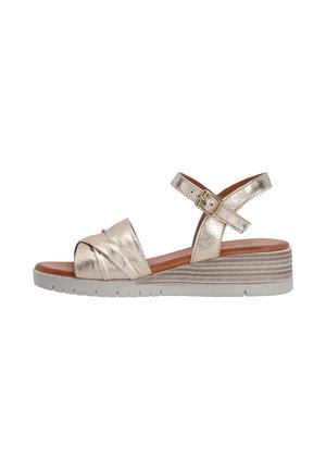 Metallic zlaté wedge sandály s křížovým páskovým designem, nastavitelným zapínáním na kotníku a texturovanou podrážkou ve světle šedé barvě s dřevitými vzory.