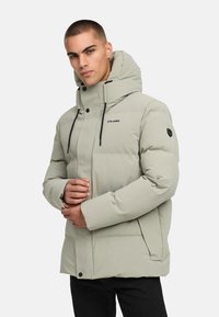 Šviesiai pilkas pūkinis švarkas su aukštu apykakle, juodu užtrauktuku ir akcentais. Savybės: sagų uždarymas ir reguliuojamos raišteliai ant gobtuvo.