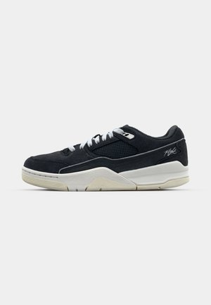 Juodos suede sportbačiai su tinklinėmis detalėmis, baltais raišteliais ir tekstūriniu padu. Šone yra sidabro logotipas. Šoninis vaizdas.