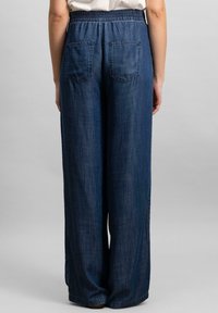 Pantaloni din denim cu picioare largi, de culoare albastru închis, cu un talie elastică și două buzunare la spate, având o textură fină.