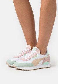 Zapatillas Puma de malla blanca y ante en tonos pastel, con acentos en rosa, menta y beige; diseño de cordones con cuello acolchado y detalle del logotipo.