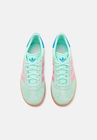 Mintgrønne ruskindsneakers med rosa striber, blå detaljer på tungen og en gummigummisål. Har snørebånd og polstret krave.