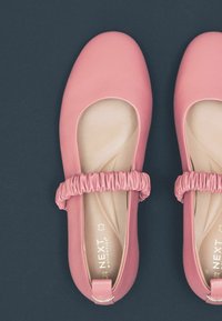 Rosa Ballerinas aus glattem, weichem Material, mit runder Zehenkappe und gerafften elastischen Akzenten um den Eingriff.