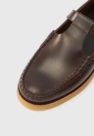 Καφέ δερμάτινο παπούτσι με ραμμένη μύτη, σχέδιο με κοψίματα κοντά στον αστράγαλο και ανοιχτόχρωμη σόλα, που αναδεικνύει μια λεία υφή.