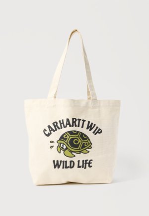 Beżowa torba na ramię z płótna z długimi uchwytami, z nadrukiem kreskówkowego żółwia oraz napisem "CARHARTT WIP WILD LIFE" w kolorze czarnym i zielonym.
