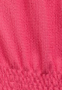 Rosa textil med en krinklad yta och en samlad elastisk nederkant, med en slät yta och oregelbundna linjer genom hela.