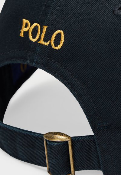Schwarze Baumwoll-Baseballmütze mit goldgesticktem "POLO"-Text, verstellbarer Riemen mit bronzener Schnalle und strukturiertem Stoff.