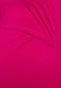 Top de jersey fúxia com detalhe de design plissado, textura suave e costura sem emendas ao longo das bordas.