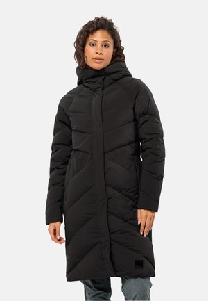 Lange zwarte pufferjas met een hoge kraag, featuring chevron-stiksels, elastische manchetten en een logopatch aan de zoom. Glad, geïsoleerd materiaal.