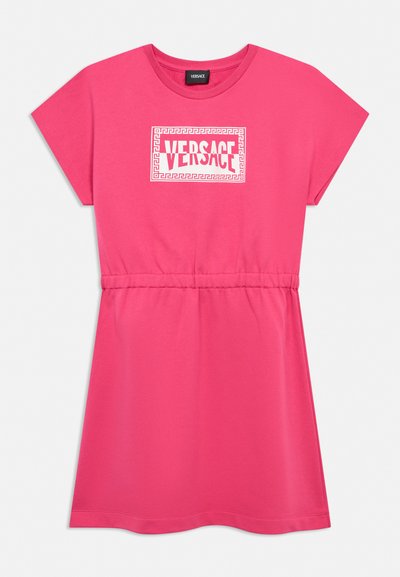 Robe rose à manches courtes avec taille froncée et logo blanc Versace encadré par un motif clé grecque sur la poitrine.