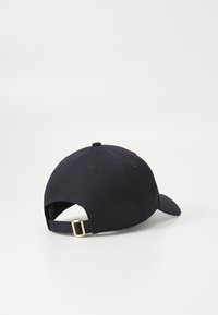 Melnas kokvilnas beisbola cepure ar izliekto malām, regulējama aizmugures siksna ar zelta sprādzi un sešiem ventilācijas caurumiem.