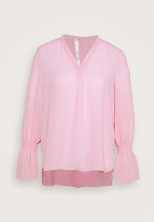 Blouse rose pâle à manches longues avec col en V et poignets élastiques froncés, présentant un ourlet arrière légèrement plus long.