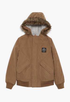 Veste d'hiver marron à capuche avec bordure en fausse fourrure, doublure en polaire, deux poches à rabat à l'avant, poignets côtelés, et un petit écusson logo noir sur la poitrine.