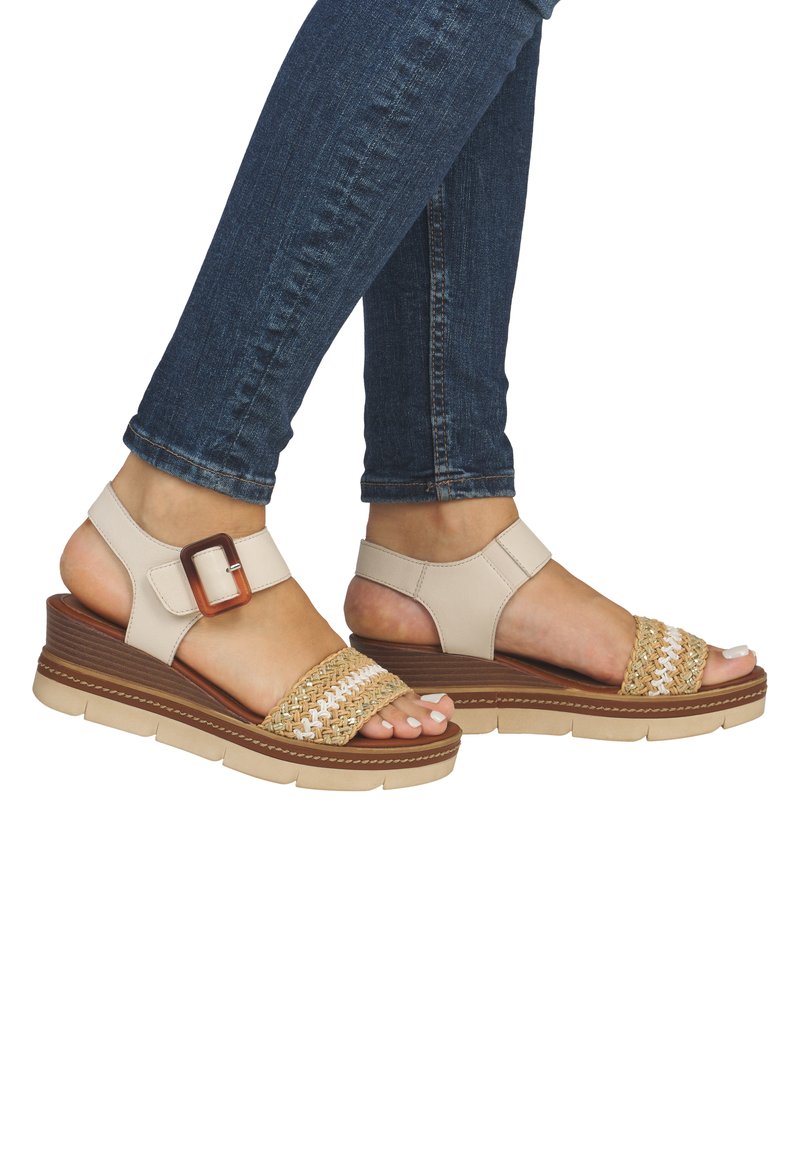 Beżowe sandały na platformie z plecionymi akcentami ze słomy, z regulowanym paskiem na kostkę i teksturowaną gumową podeszwą.