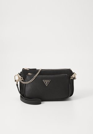 Sort tekstureret Guess crossbody taske med front lynlåslomme, guldkæde detaljer og justerbar rem på en ensfarvet hvid baggrund.