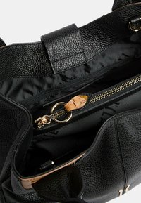 Borsa tote in pelle nera con finitura testurizzata, dotata di una tasca interna con zip, dettagli in oro e foderata con tessuto morbido.
