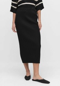 Czarna, prążkowana, midi spódnica z dopasowaną talią. Tkanina ma teksturowane wykończenie, oferując dopasowany krój. Prosty i elegancki design.