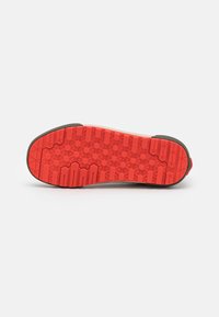 Gummisula i en livlig röd färg med ett sexkantigt mönster för grepp, kantad med en mörkare gummikant.