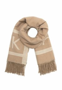 Beżowy wełniany szalik z jasnobeżowymi geometrycznymi wzorami i frędzlami na końcach, złożony w luźną pętlę na białym tle.