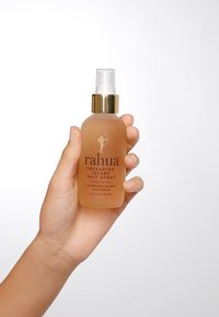 Rahua Enchanted Island Salzspray in einer klaren Glasflasche mit einem goldenen Pumpspender und einer beigefarbenen Flüssigkeit; 124 ml Kapazität; aus Regenwaldpflanzen.