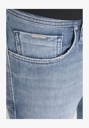 Džep od svijetloplavog trapera s malim prednjim džepićem za novčiće i metalnom oznakom marke "Antony Morato" iznad džepića za novčiće.