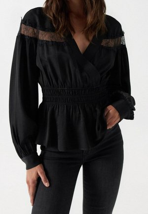 Czarna bluzka z kopertowym fasonem, marszczonym paskiem w talii, długimi rękawami, przejrzystymi koronkowymi akcentami na ramionach oraz miękką, teksturowaną tkaniną.
