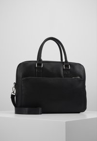 Schwarze Lederaktentasche mit strukturierten Oberflächen, doppelten Tragegriffen und einem abnehmbaren Schultergurt. Vordertasche mit Reißverschluss für zusätzlichen Stauraum.