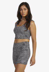 Black and white striped crop top and shorts set, featuring a textured fabric and small logo patches on both pieces.