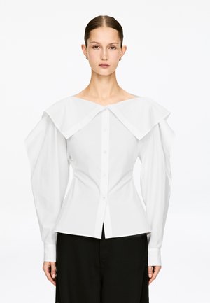 White button-up shirt with an oversized, structured collar and long, puffed sleeves. Tailored fit with a slightly flared hemline.
