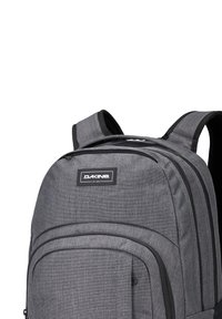 Grijze stoffen rugzak met gewatteerde schouderbanden, logopatch, meerdere ritscompartimenten en een gestructureerd oppervlak voor duurzaamheid.