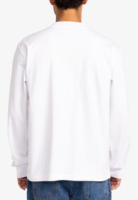 Witte lange mouwen shirt met een ronde halslijn, gemaakt van zacht katoen, en een rechte zoom. Kenmerkt subtiele stiksels nabij de manchetten.