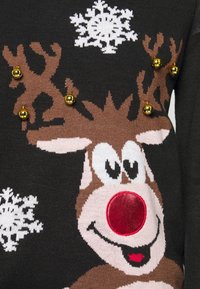 Pull en tricot noir avec un renne de dessin animé au nez rouge, entouré de flocons de neige blancs et orné de clochettes dorées.