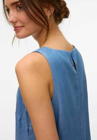 Modra denim obleka brez rokavov z odprtino na zadnji strani in gladko strukturo, z enostavnimi linijami in sproščenim krojem.