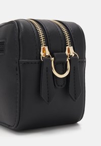 Sac rectangulaire noir en matériau synthétique structuré, doté de deux zips dorés, d'accents en matériel doré et d'une petite poche latérale.