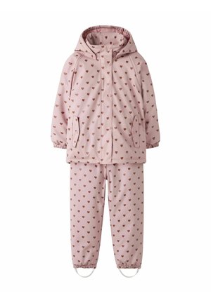 Combinaison de pluie enfant deux pièces rose imperméable avec capuche et motif de petits cœurs marron sur l’ensemble, poignets élastiqués et sangles aux pieds du pantalon.