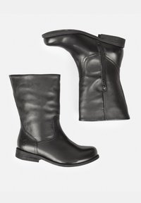 Botas de cuero negro con una textura suave, altura a media pantorrilla, detalle de cremallera lateral y un tacón bajo y redondeado. Diseño minimalista con logotipo grabado.