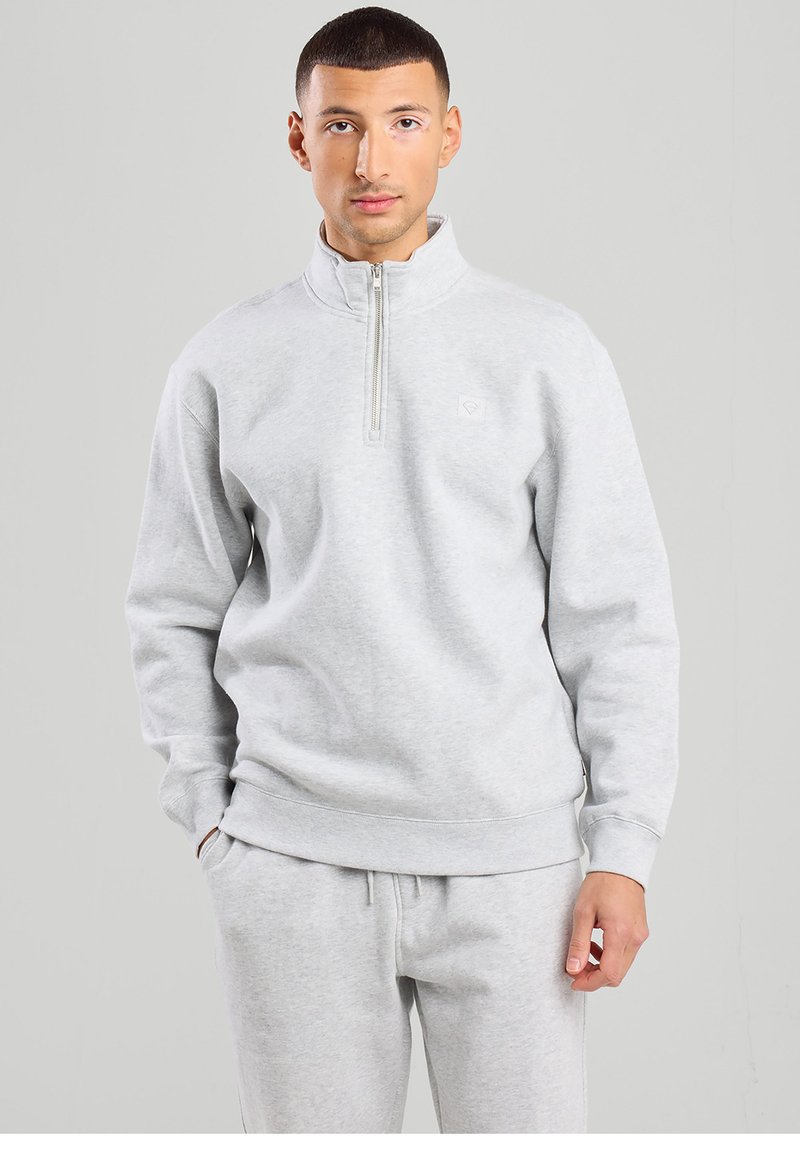 Light gray zip-up sweatshirt made from soft fabric, featuring a high collar, ribbed cuffs, and a small logo on the chest.